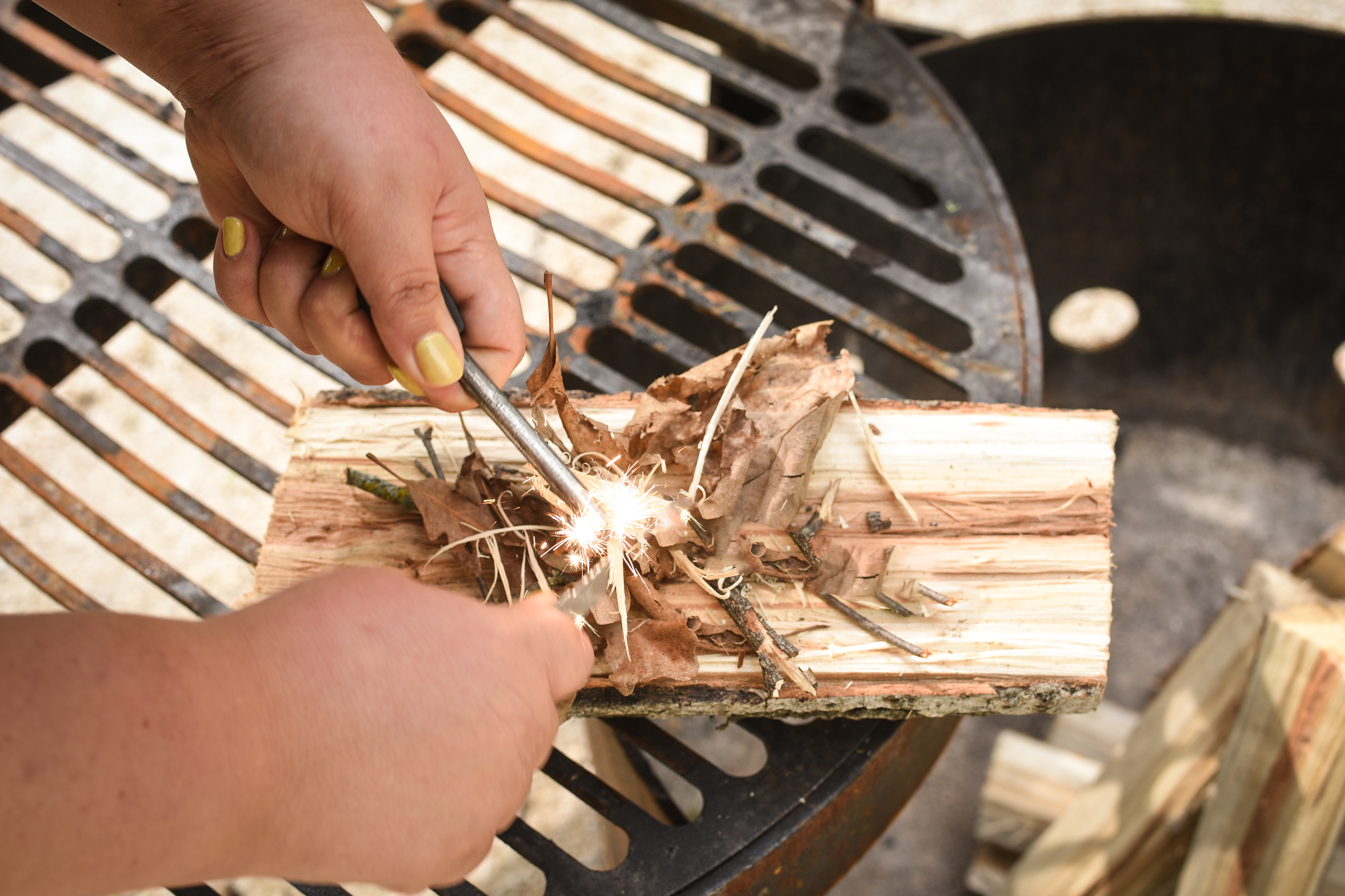 Creating sparks onto a pile of wood shavings with Coghlan's Flint Striker